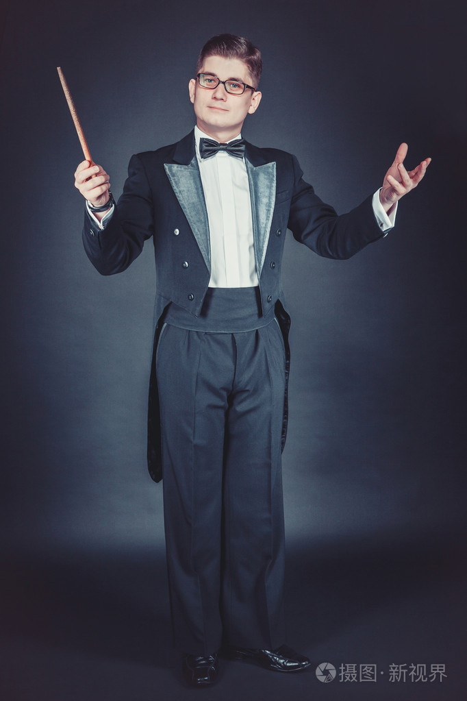 穿着礼服的年轻男子.指挥用指挥棒