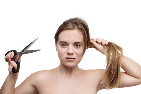 长头发的年轻妇女剪它与一把剪刀有一个坏头发一天