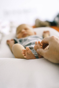 新生儿的脚躺在婴儿茧和父亲的手轻轻触摸, 做一个温柔的按摩