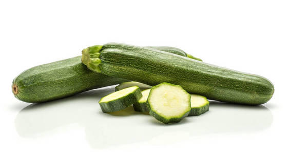 两个新鲜小胡瓜交错白色背景上的两个绿色西葫芦和五片堆叠生西葫芦