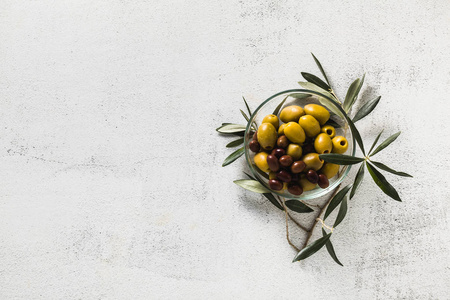 在透明的碗和橄榄树的树枝的橄榄品种。小吃或开胃菜。开胃菜