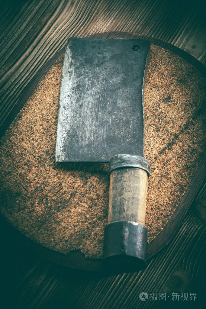 老式屠夫肉菜刀在软木板上