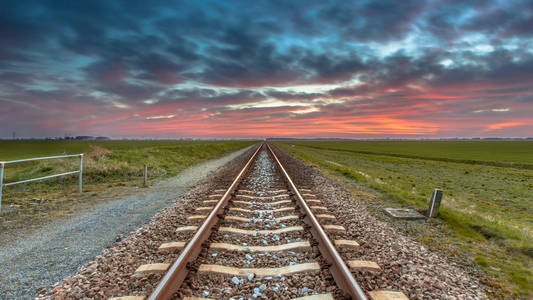 消失的铁路旅行到地平线下的蓝色和红色的天空作为一个概念的天堂和自由
