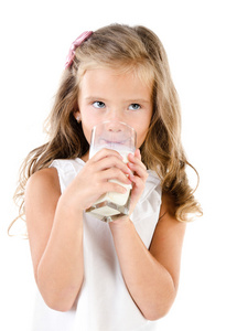 微笑的小女孩喝牛奶孤立在一张白纸