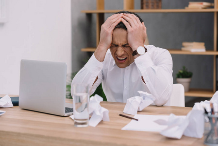 办公头痛在办公室的成熟生意人与痛苦的偏头痛照片