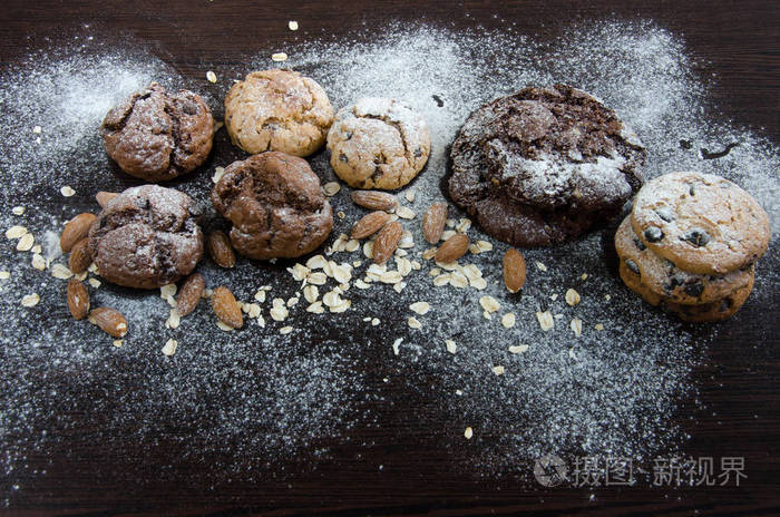 饼干与巧克力在黑暗的背景下, 糖粉, 燕麦片, seasame 和杏仁。Copyplace, 地方为文本