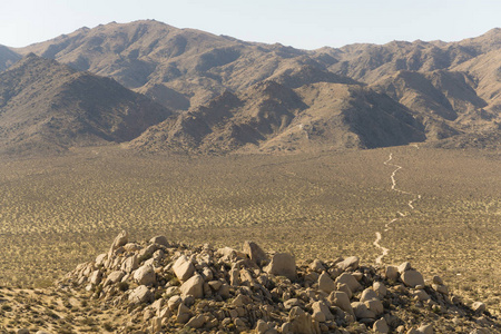 一个安静的尘土飞扬的道路蜿蜒穿过岩石沙漠地板在南加州