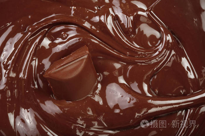 融化的巧克力和一块巧克力棒作为背景特写