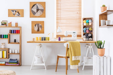 色彩缤纷的房间内有书桌, 缝纫机和缝纫线的真实照片