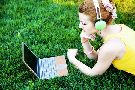 年轻女子在公园的笔记本电脑休息