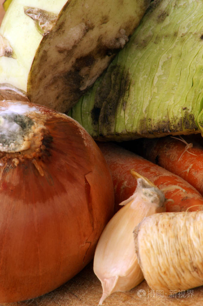 木制切板上的发霉蔬菜堆特写