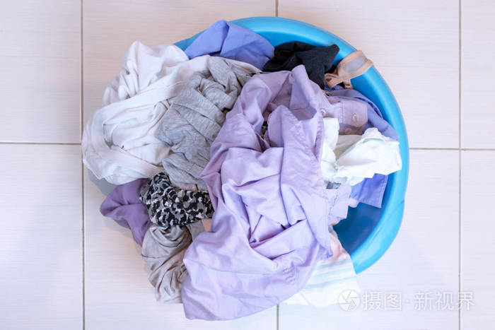 浴室地板上满是脏衣服的水池洗涤概念
