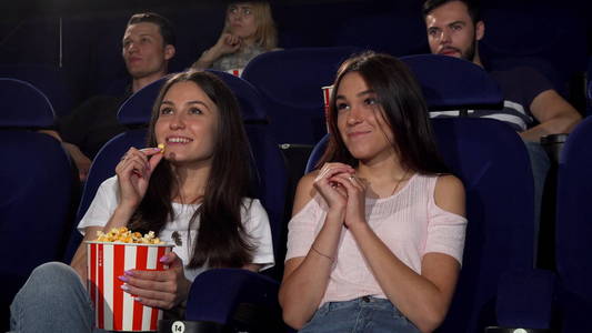 美丽的年轻妇女喜欢看电影在电影院