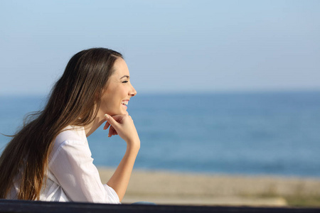 在海滩上期待的微笑的妇女照片