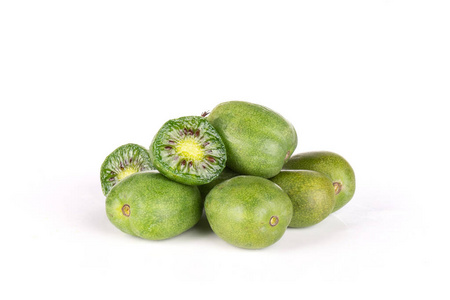 在白色背景查出的新鲜绿色迷你婴儿猕猴桃水果的大量的一堆全两半