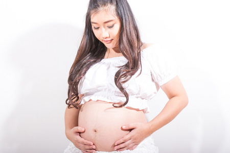 孕妇抚摸她的肚子里在白色背景