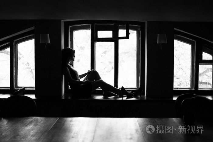 黑发女人坐在窗台上