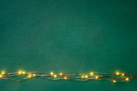 圣诞节灯花环边框在绿色背景。平躺, 复制空间