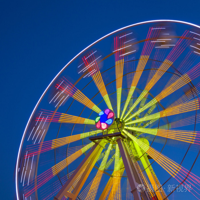 在暗蓝的天空背景上的摩天轮旋转木马