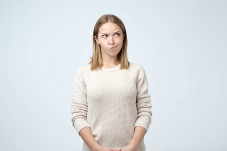 的女人脾气暴躁的年轻白种女人, 恼火的样子和皱眉, 感到不满的东西