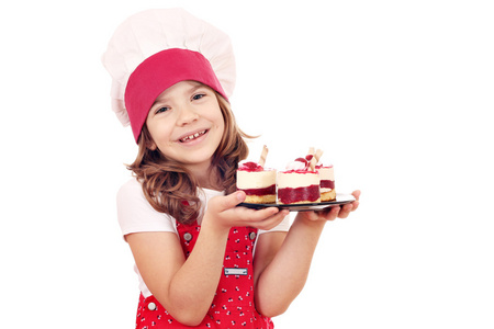 快乐的小女孩用甜甜的覆盆子蛋糕做饭