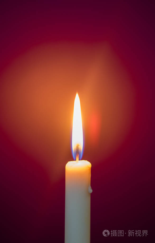 燃烧的蜡烛红色的背景上