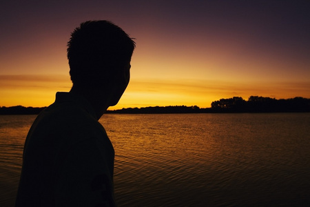 一个人跨湖过来看日落的轮廓图片