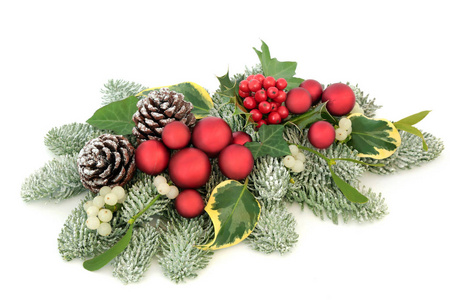 圣诞节餐桌装饰与红色摆设装饰, 冬青浆果, 雪覆盖云杉松树, 常春藤, 松树锥和槲寄生查出的白色背景