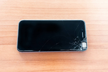 手机的屏幕破了黑色背景和碎玻璃破碎的智能手机卡通碎的玻璃片特写