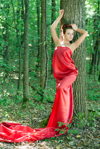 年轻漂亮的女人，穿着红色的绿色树林