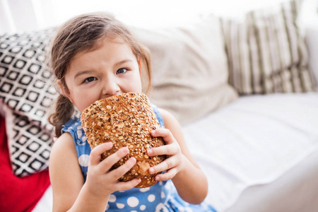 一个小女孩在家里吃一块面包