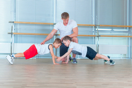 一群孩子在健身房和老师一起做孩子体操。快乐运动的孩子在健身房。酒吧锻炼。木板