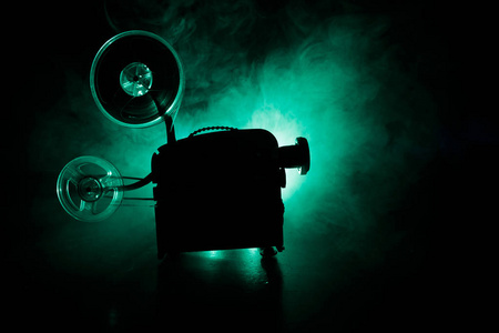 老式电影投影机, 静物, 特写。电影投影机在一个木质背景与戏剧性的照明和选择性的焦点。电影和娱乐概念