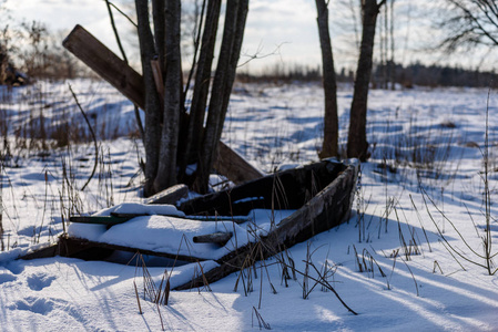 冬天的乡村景象与雪和树干在寒冷。老船