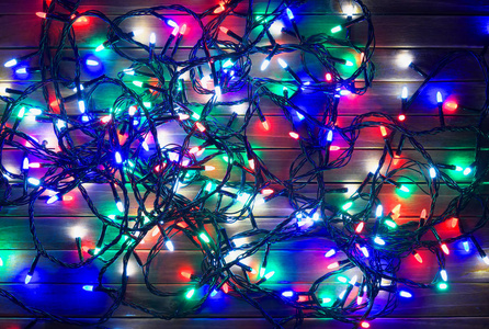 假日花环在晚上。圣诞节背景木带五颜六色的灯光。顶部视图