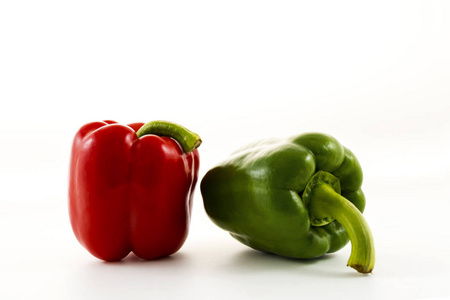 红色甜甜椒和绿色甜铃胡椒被隔绝在白色背景上