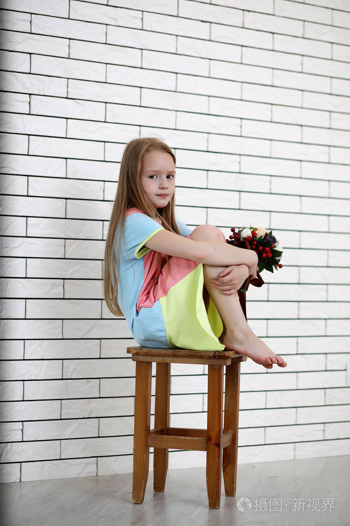 小女孩正坐在椅子上