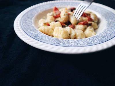 意大利传统汤团。传统的意大利汤团与干西红柿, 帕尔马干酪, 融化大蒜黄油与草药