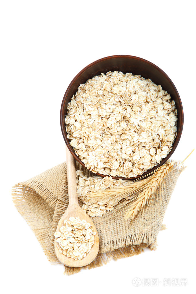 在白色背景上的碗燕麦粥片.健康的食物