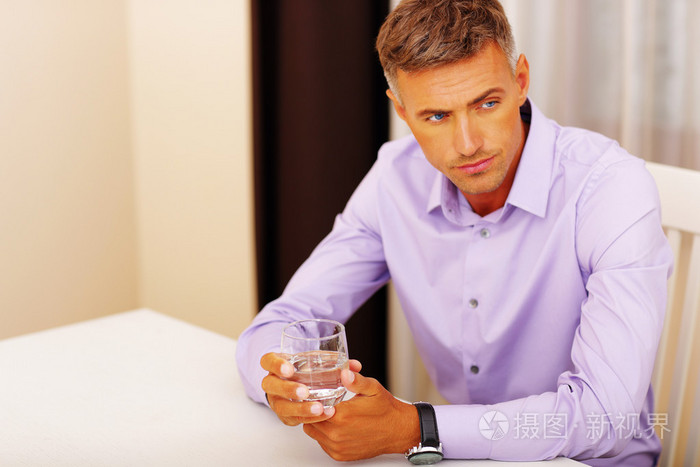 英俊的忧郁男人喝水