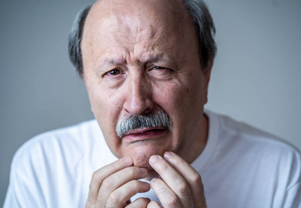 年长的成年老人在痛苦与疲惫的脸在人的情感的肖像面部表情退休和抑郁概念隔离在中立背景下