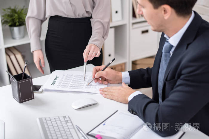 在现代办公室与秘书在办公桌上成功的企业高管签署合同的肖像
