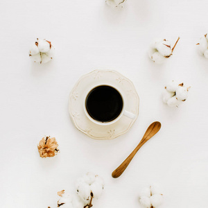 Flatlay 的咖啡杯, 木勺和棉花芽的白色背景。顶部视图