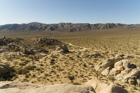 一个安静的尘土飞扬的道路蜿蜒穿过岩石沙漠地板在南加州