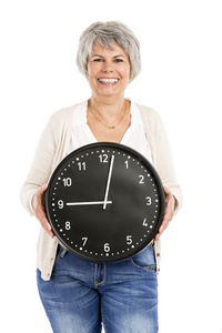 老年妇女抱着一个时钟