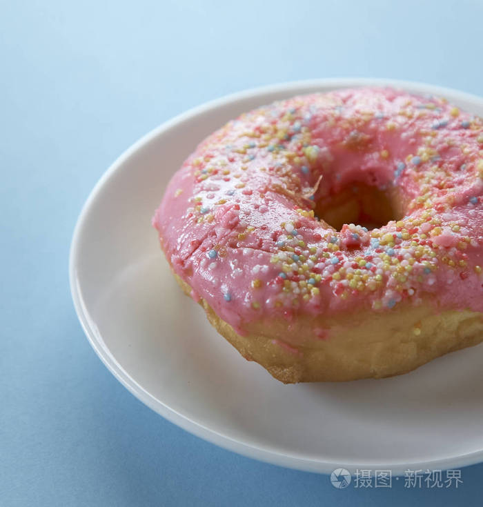 蓝色背景上的一个粉红色甜甜圈