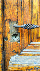 复古黄木门配饰柄和钥匙孔照片