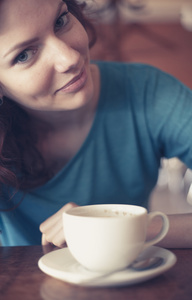 rdhriga kvinnor sitter i cafee med kopp kaffe