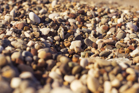 小圆形棕色和橙色的岩石，在一个折中的海滩上