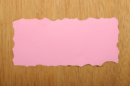 粉红色的烧过的纸木制背景上